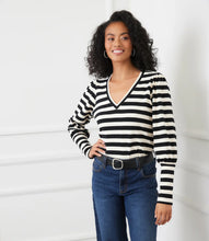 Load image into Gallery viewer, Woman wearing a black and cream striped long-sleeve top, blue jeans and black belt against a white background.