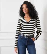 Load image into Gallery viewer, Woman wearing a black and cream striped long-sleeve top, blue jeans and black belt against a white background.