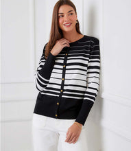 Load image into Gallery viewer, Woman wearing a black and off-white striped cardigan sweater and white pants against a white background.