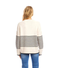 Load image into Gallery viewer, Woman wearing an ecru sweater with black stripes and jeans against a white background.