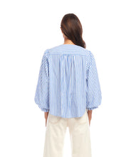 Load image into Gallery viewer, Woman wearing a blue and white striped blouse against a white background.