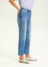 Load image into Gallery viewer, These eye-catching jeans in a medium wash, feature rhinestone embellishments on each leg, adding a touch of sparkle and elegance to the classic design. With a high-rise waist and a straight-leg shape, they offer a flattering fit and timeless style. The ankle length makes them perfect for pairing with heels or flats.