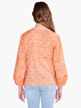 Load image into Gallery viewer, This bright and festive shirt takes your next casual look in an all-new direction. Tie the front to make a keyhole opening or leave it open. The design includes bracelet cuffs and flowy bishop sleeves. Sits just below the waist in an easy fitting silhouette. Color-Orange multi. Easy fit. Round neck. Bracelet sleeve. Bishop sleeve.