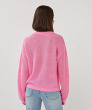 Load image into Gallery viewer, Person wearing an open knit pink sweater and blue jeans on a plain background.