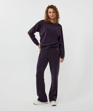 Load image into Gallery viewer, The EsQualo W2405714 Trine Trousers boast a luxurious satin finish and soft, breathable modal fabrication. The dark purple hue adds a touch of elegance, making them versatile for both casual and dressy occasions. With convenient satin pockets, zipper pockets, and a shimmering lurex drawstring, these trousers are both functional and stylish.