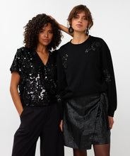 Load image into Gallery viewer, Two women wearing black outfits with sequin details against a white background.