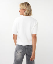 Load image into Gallery viewer, Woman wearing an off-white top, silver earrings and grey pants against a white background.