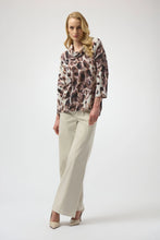 Load image into Gallery viewer, Woman wearing an off-white and brown multi animal print tunic sweater, off-white pants and off-white heels against a white background.