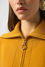 Load image into Gallery viewer, Close-up of a mustard yellow top with a gold zipper and gold earrings.
