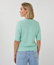 Load image into Gallery viewer, Woman wearing a light mint green short sleeve sweater, and blue jeans on a white background.