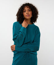 Load image into Gallery viewer, Woman wearing a teal modal sweater with floral embroidery and teal pants against a white background.