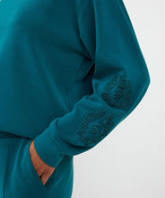 Load image into Gallery viewer, Teal modal sweater with embroidered design on sleeve and teal pant against a white background.