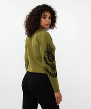 Load image into Gallery viewer, Our Sanne sweater is a work of art and a masterpiece of comfort and style. This olive-green sweater features elegant puff sleeves and intricate black stitching details. Crafted with anti-pilling acrylic, it promises durability and superior quality.