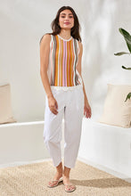 Load image into Gallery viewer, Woman wearing a striped sleeveless top and white pants in a bright room.