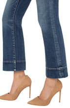 Load image into Gallery viewer, Close-up of blue jeans with wide hems and beige high-heeled shoes against a white background.
