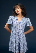 Load image into Gallery viewer, Classic, clean, and effortlessly chic—the Navy Dress by Smith & Quinn is a timeless staple reimagined in the charming Bluebonnet print. This sleeveless silhouette features a tailored bodice, flattering V-neckline, and gently flared skirt that moves with ease. Crafted from Smith & Quinn’s signature stretch fabric, it offers wrinkle resistance and breathable comfort, making it ideal for warm-weather occasions or polished everyday wear.