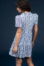 Load image into Gallery viewer, Classic, clean, and effortlessly chic—the Navy Dress by Smith & Quinn is a timeless staple reimagined in the charming Bluebonnet print. This sleeveless silhouette features a tailored bodice, flattering V-neckline, and gently flared skirt that moves with ease. Crafted from Smith & Quinn’s signature stretch fabric, it offers wrinkle resistance and breathable comfort, making it ideal for warm-weather occasions or polished everyday wear.