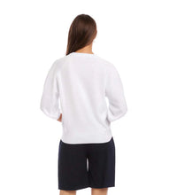 Load image into Gallery viewer, Woman wearing a white sweater and black shorts on a white background.