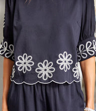Load image into Gallery viewer, Add a touch of timeless elegance to your wardrobe with the Tesni Three Quarter Sleeve Embroidered Scallop Top by Karen Kane. Featuring delicate floral embroidery, a scalloped hem, and chic puff sleeves, this sophisticated blouse offers a graceful yet modern look for any occasion. Perfect for brunch, workdays, or an evening out, this lightweight embroidered top pairs effortlessly with jeans, skirts, or tailored pants.