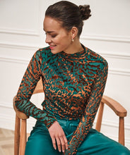 Load image into Gallery viewer, Woman wearing an animal print top in burnout velvet in teal and brown and teal pants sitting on a wooden chair.