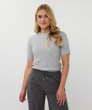 Load image into Gallery viewer, Woman wearing short sleeve grey sparkly top with gray pinstripe pants against a light gray background.