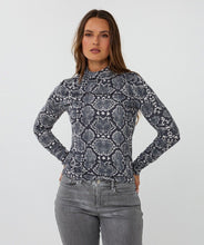 Load image into Gallery viewer, Woman wearing a snake print long-sleeve top and gray pants against a white background.