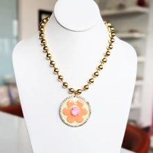 Load image into Gallery viewer, The Toshka Peach Necklace makes a bold statement. Its unique blend of antique gold, smutt-plated brass and a floral hand-painted enamel is enhanced with high quality Swarovski crystal.
