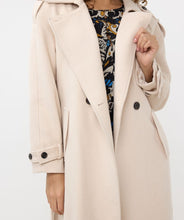 Load image into Gallery viewer, Classic, chic, and timeless, this stunning EsQualo Trenchcoat in a beautiful bisquit color is a must-have. The chic long trench coat features a bow belt and beautiful button details on the hem, sleeves, and shoulders, making it a perfect blend of elegance and sophistication.