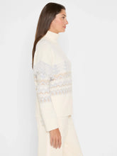 Load image into Gallery viewer, Woman wearing a cream and blue fringe detailed turtleneck sweater and cream pants against a white background.