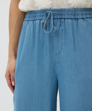Load image into Gallery viewer, The EsQualo Tudi Trousers Chambray are wide-leg, lightweight pants crafted from 100% Lyocell, offering a soft, breathable feel perfect for warm-weather styling. Designed with an elastic waistband and drawstring, these trousers provide effortless comfort and a relaxed fit. Their versatile chambray fabric pairs beautifully with summer tops, making them a must-have for casual chic looks.