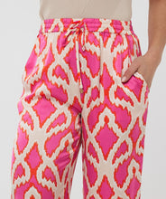 Load image into Gallery viewer, The EsQualo Taimi Trousers Disco Spark are a bold and stylish statement piece designed for effortless elegance. Featuring a vibrant pink-orange disco spark print, these trousers bring energy and sophistication to any outfit. Pair with a fitted top for a sleek contrast or a matching blouse for a coordinated ensemble.