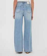 Load image into Gallery viewer, Close-up of model wearing blue jeans with embroidery and natural sandals against a white background.
