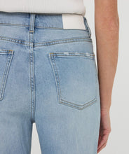 Load image into Gallery viewer, Close-up of back pockets on light blue jeans.