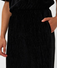 Load image into Gallery viewer, Close-up or model wearing black velours pants with pockets.