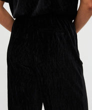 Load image into Gallery viewer, Close-up of model wearing black velours pants.