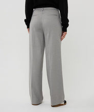 Load image into Gallery viewer, Woman wearing a black sweater, gray pants and black shoes against a white background.