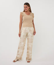 Load image into Gallery viewer, Woman in a beige sleeveless top and white and beige safari pants standing against a white background.