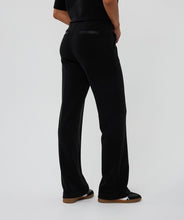 Load image into Gallery viewer, Model wearing black pants and sneakers against a white background.