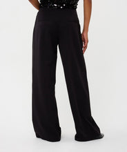 Load image into Gallery viewer, Black wide-leg pants worn by a model against a white background.