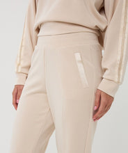 Load image into Gallery viewer, Close up model wearing beige pant against a white background.
