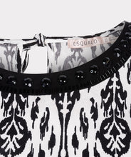 Load image into Gallery viewer, This black and white top features an elegant sleeveless design with a delicate bow at the back and beaded neckline. Perfect for wearing on its own or layering with a jacket or blazer. Experience the timeless chic of an ikat print with this stunning top.