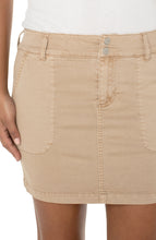 Load image into Gallery viewer, Introducing the new skort by Liverpool Los Angeles! Enjoy the look of a skirt with great coverage thanks to the comfortable spandex shorts underneath. Comfortable and easy to wear, this skort gives you a cool, utility look. The Bisquit tan color makes this skort a perfect style to wear with so many of your favorite tops! Color - Bisquit Tan- Tan. Skirt: 17" Center Front Length. Short: 5'' Inseam. 7-5/8" Front rise; 17-1/2" Leg opening. Utility stitch pockets. Logo button and zip closure.