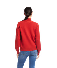 Load image into Gallery viewer, Woman wearing a red cardigan and blue jeans against a white background.