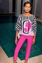 Load image into Gallery viewer, The charm of this breezy poncho top lies in its vibrant abstract print. Crafted from airy georgette, it showcases a boat neckline and generous dolman sleeves. This distinctive top is lined and includes a silky knit camisole beneath for added comfort. Color- Vanilla, pink and black. Georgette poncho with silky knit camisole. Boat neckline. Three-quarter dolman sleeves. Lined.
