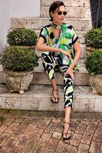 Load image into Gallery viewer, Introducing the Amaya Abstract Print Millennium Pull-On Pants by Joseph Ribkoff. Designed with a structured contour waistband and a stylish JR ornament, these cropped pants offer sophistication and comfort. Crafted from high-quality fabric, they provide both luxury and fun. Elevate your wardrobe with these bold and stylish pants. Color - Vanilla Multi - Key lime, black and vanilla. Millennium fabric. Structured contoured waistband. JR ornament detail. Unlined.