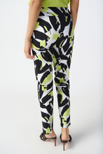 Load image into Gallery viewer, Introducing the Amaya Abstract Print Millennium Pull-On Pants by Joseph Ribkoff. Designed with a structured contour waistband and a stylish JR ornament, these cropped pants offer sophistication and comfort. Crafted from high-quality fabric, they provide both luxury and fun. Elevate your wardrobe with these bold and stylish pants. Color - Vanilla Multi - Key lime, black and vanilla. Millennium fabric. Structured contoured waistband. JR ornament detail. Unlined.