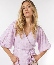 Load image into Gallery viewer, Equalize your fashion game with this stylish seersucker blouse in a show stopping violet. The wrap style and billowy elasticized elbow sleeves are perfect for creating a flattering silhouette. With its modern look and timeless quality, you'll be turning heads for seasons to come.