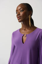 Load image into Gallery viewer, This stunning tunic designed by Joseph Ribkoff offers a graceful fit and an eye-catching look, with a vivid violet hue and a silver-ring keyhole detail on both the front and the back. Its effortless style ensures that it will be a statement piece in your wardrobe. Color- Violet. Tunic length. Keyhole design. Silver ring hardware in front and back. Fabric- 96% Polyester. 4% Spandex.
