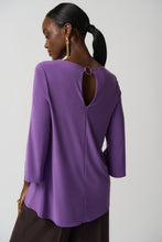 Load image into Gallery viewer, This stunning tunic designed by Joseph Ribkoff offers a graceful fit and an eye-catching look, with a vivid violet hue and a silver-ring keyhole detail on both the front and the back. Its effortless style ensures that it will be a statement piece in your wardrobe. Color- Violet. Tunic length. Keyhole design. Silver ring hardware in front and back. Fabric- 96% Polyester. 4% Spandex.