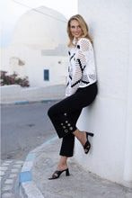 Load image into Gallery viewer, The black above-the-ankle pants are a versatile wardrobe staple, offering endless possibilities for effortless style. The silver rivet embellishments elevate the look of a basic black pant and create an eye-catching silhouette. With their timeless elegance and flattering fit, they seamlessly pair with any top or shoe, making them a go-to choice for both casual and formal occasions.